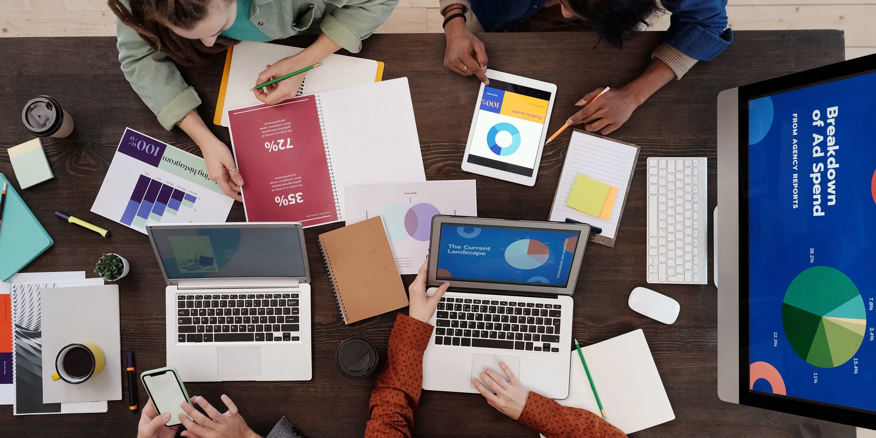Overlegtafel met laptops, analyses en campagneplanning
